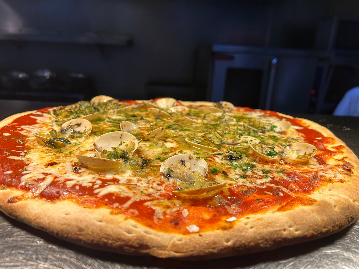 Pizza with various toppings on a dark surface