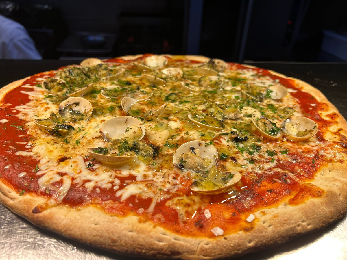 Pizza with mushrooms and herbs on a metal surface