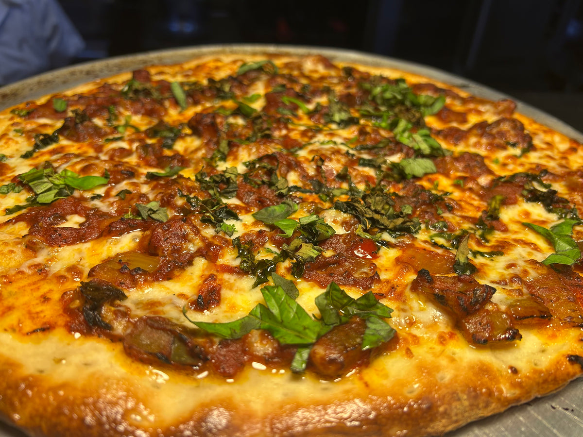 Close-up of a pizza with toppings on a metal pan