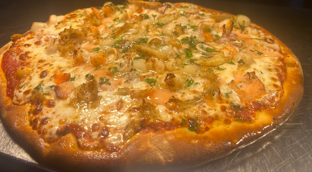 Personal-sized pizza with various toppings on a metal surface