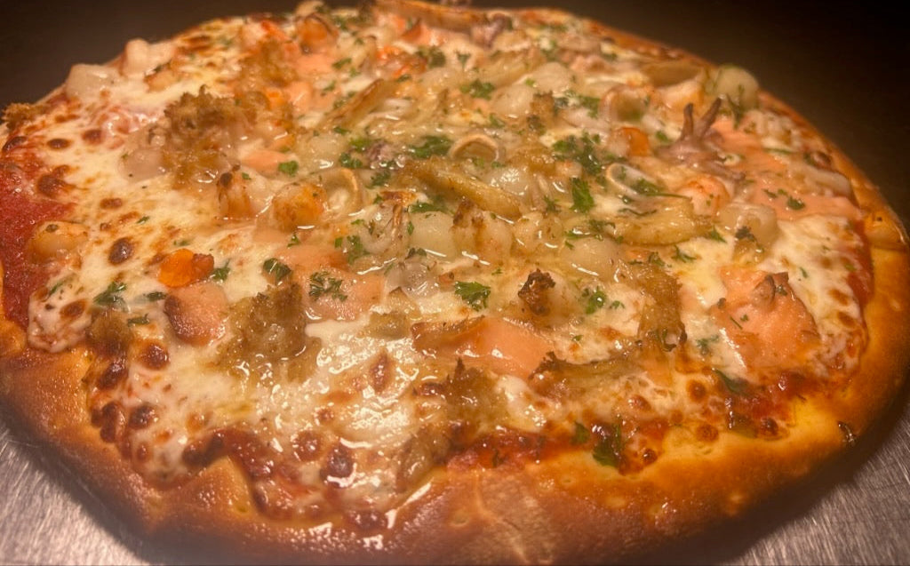 Close-up of a pizza with various toppings on a wooden surface