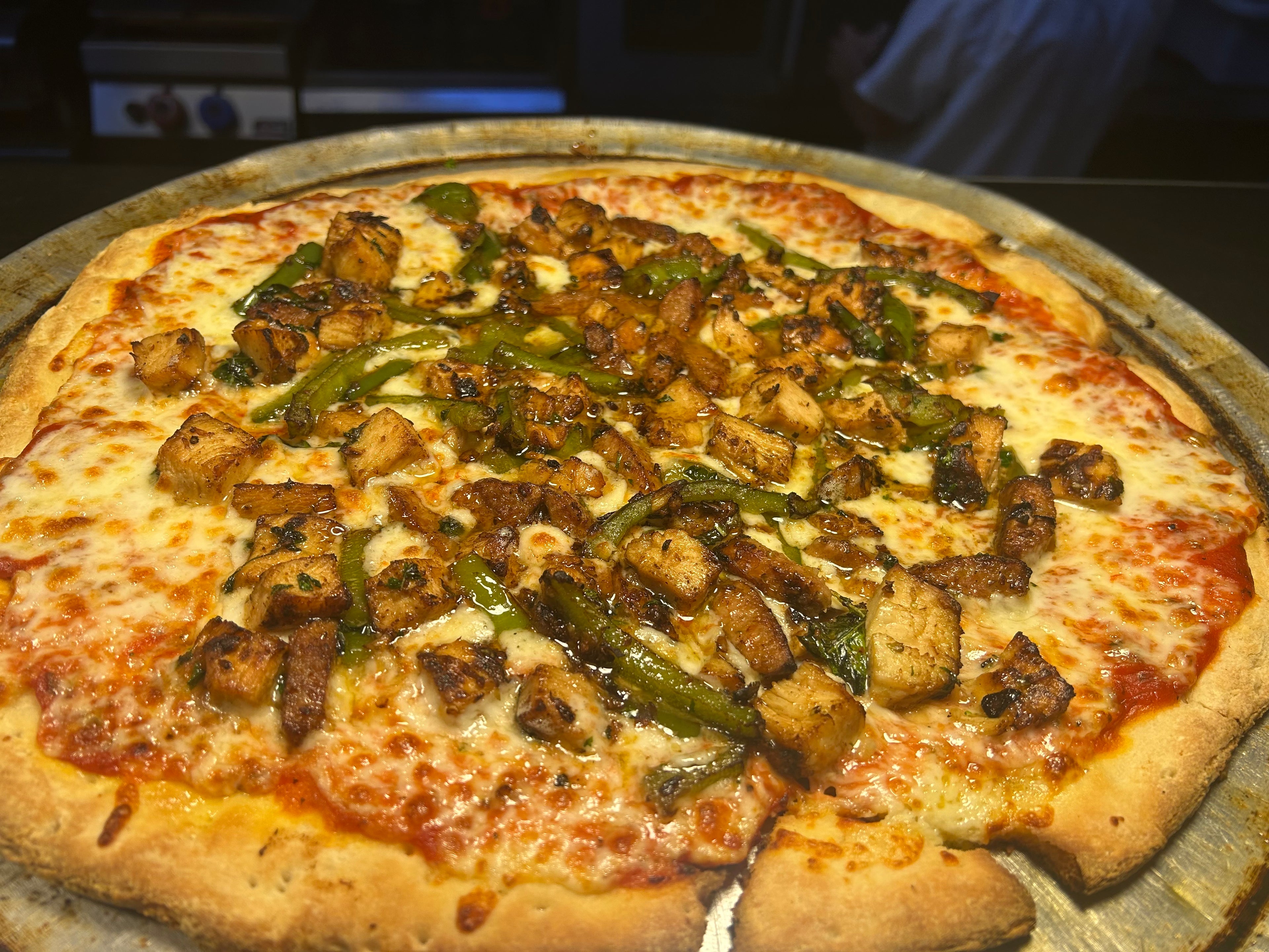 Pizza with vegetables on a metal tray