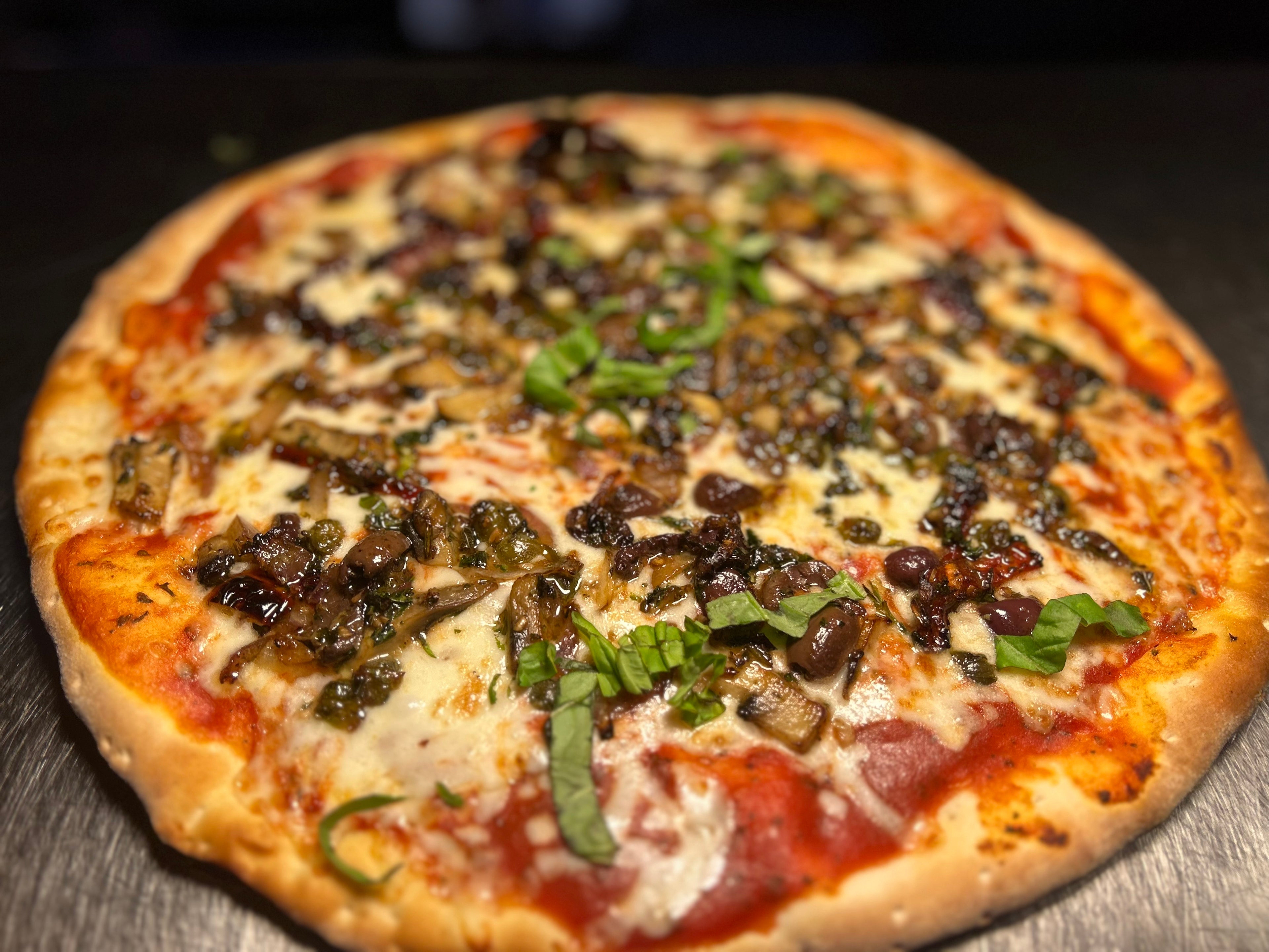 Close-up of a pizza with various toppings on a wooden surface