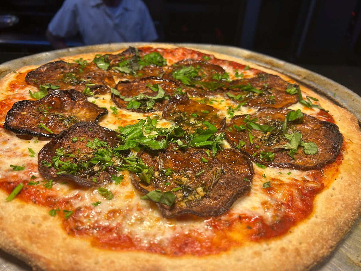 Pizza with eggplant and herbs on a metal tray